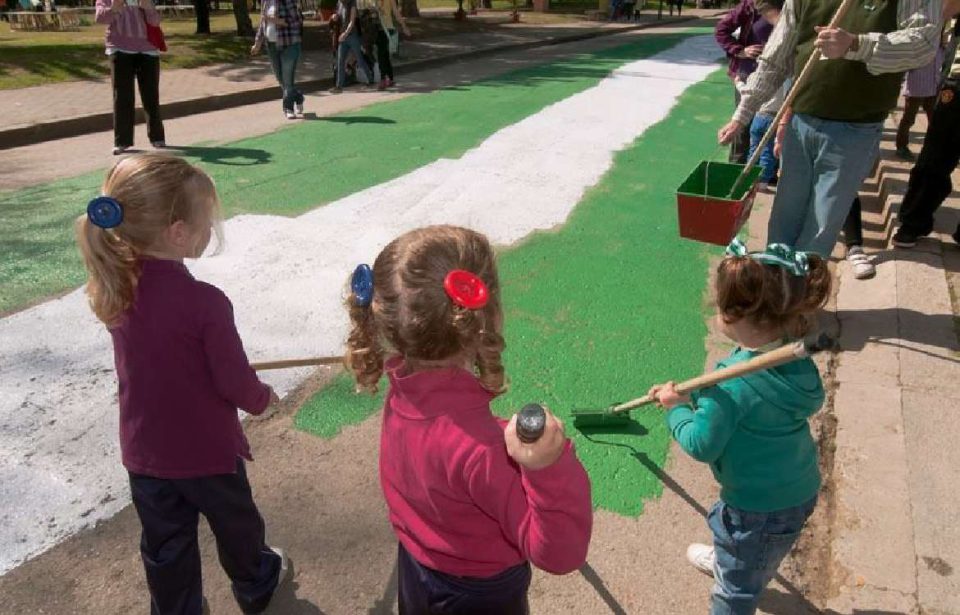 Varios niños pintan la bandera de Andalucía en el Parque del Alamillo para celebrar el 28F